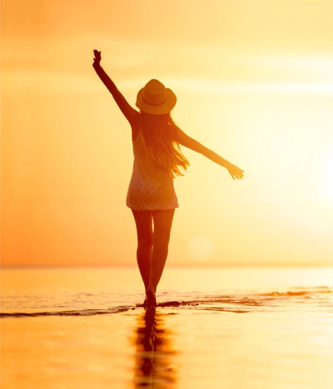 Woman on the beach at sunset