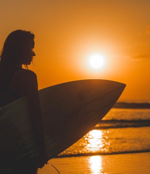 Woman holding a surfboard on the beach